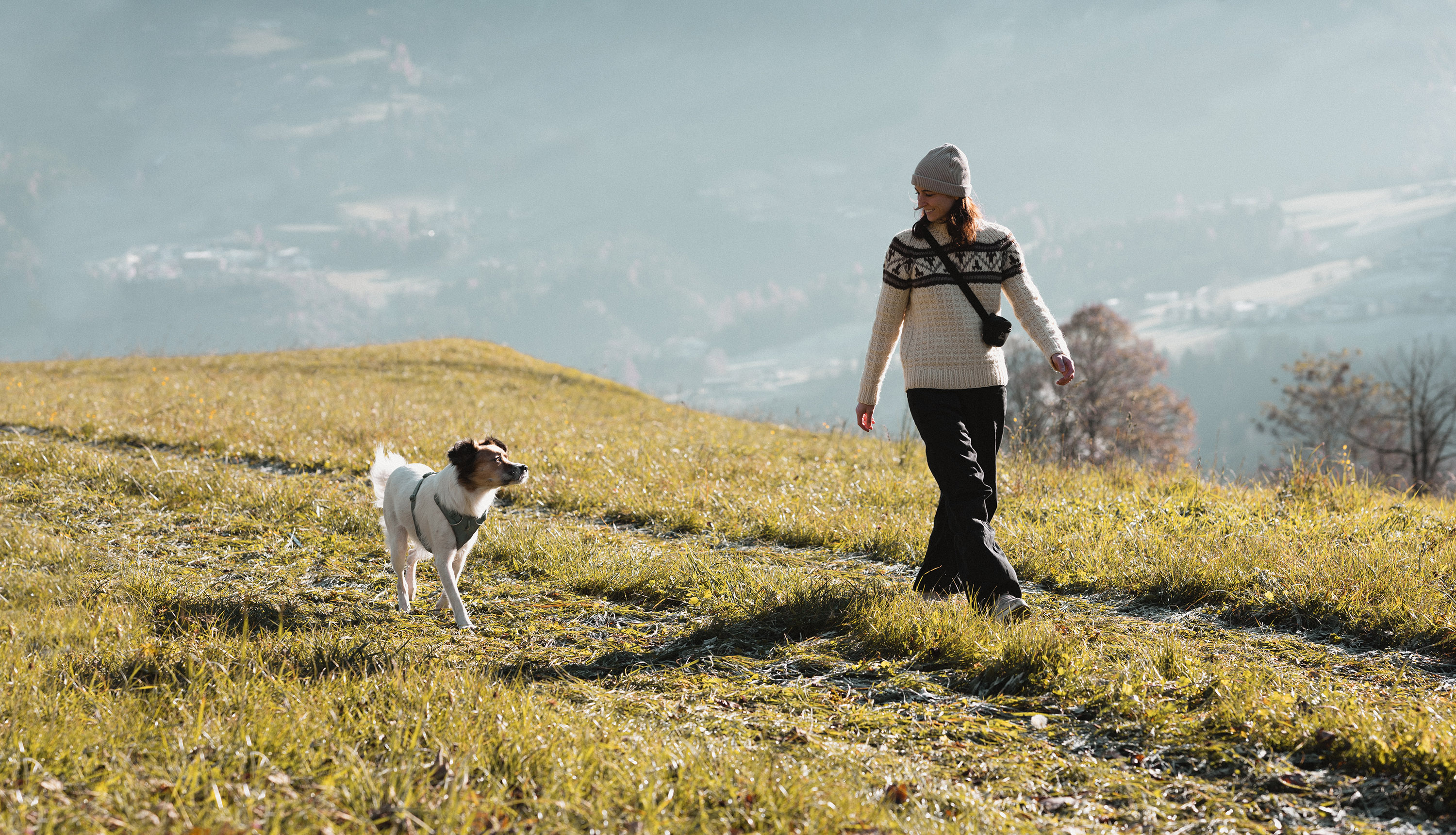 Hundetrainerin Katja Stadler und ihre Hündin Lucy gehen auf einem Feldweg spazieren und sehen sich dabei an.